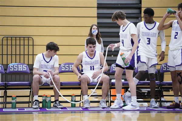 SSHS basketball game players getting water and sitting down on the sideline