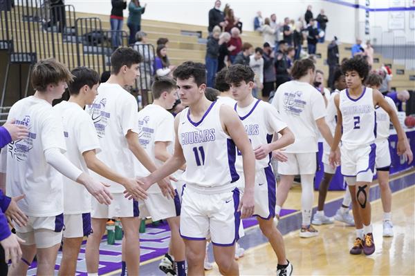 Spanish Springs Boys Basketball Team in a line high-fiving eachother.