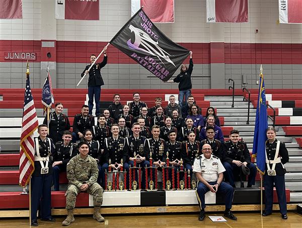 Spanish Springs JROTC posing around seven trophies at the Wooster drill meet