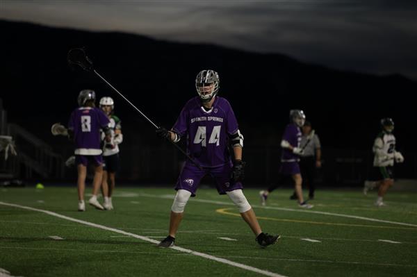 A Spanish Springs lacrosse player, tired from the game with the racket in his hand.